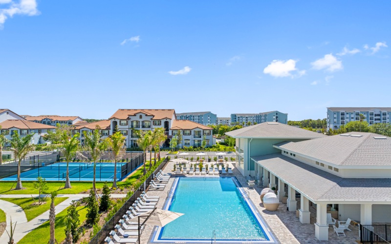 spacious pool deck with two pickleball courts