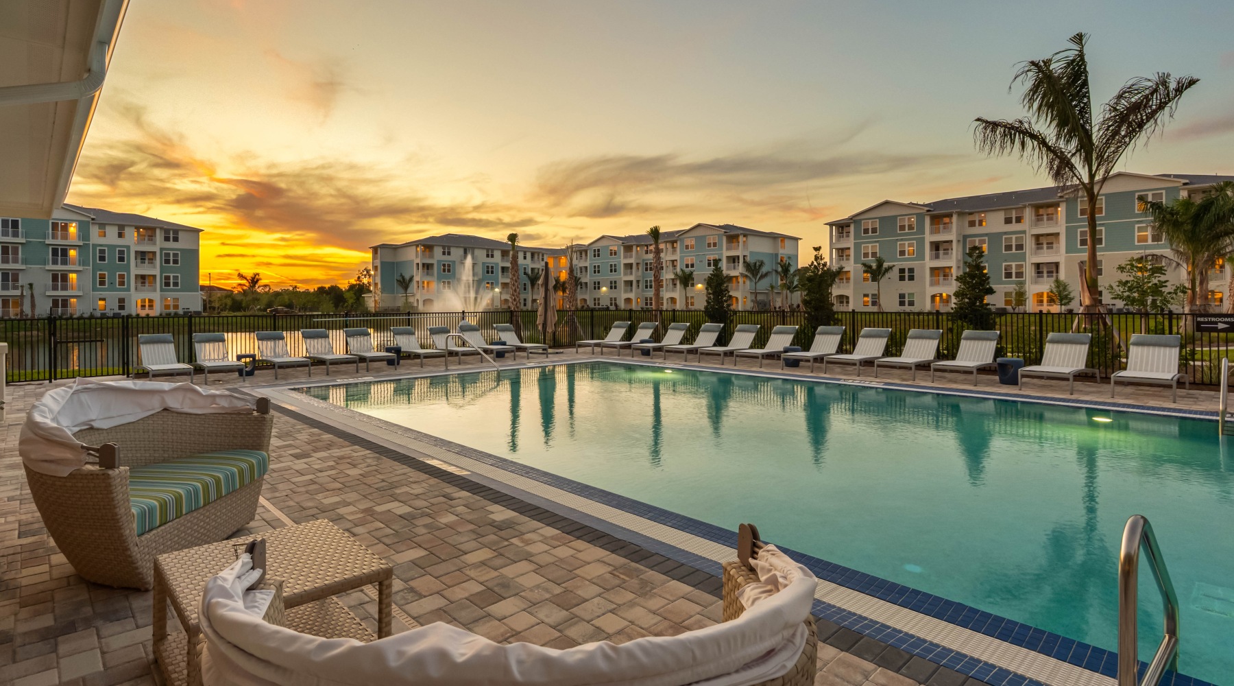 beautiful pool scene at sunset with a fountain lake in the background