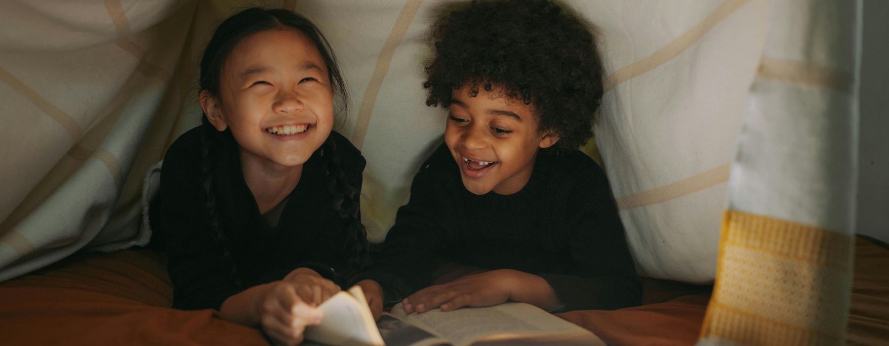 a couple of children sitting at a table smiling at the camera