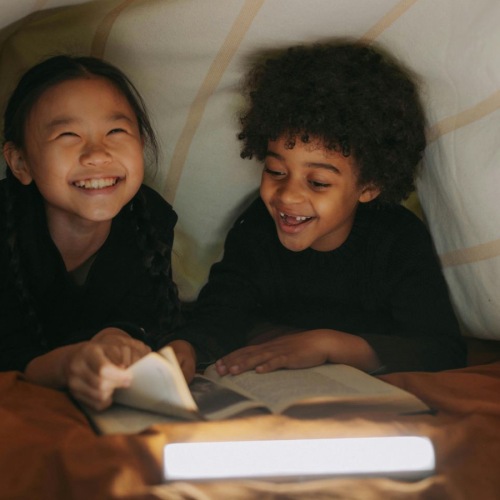 a couple of children sitting at a table smiling at the camera